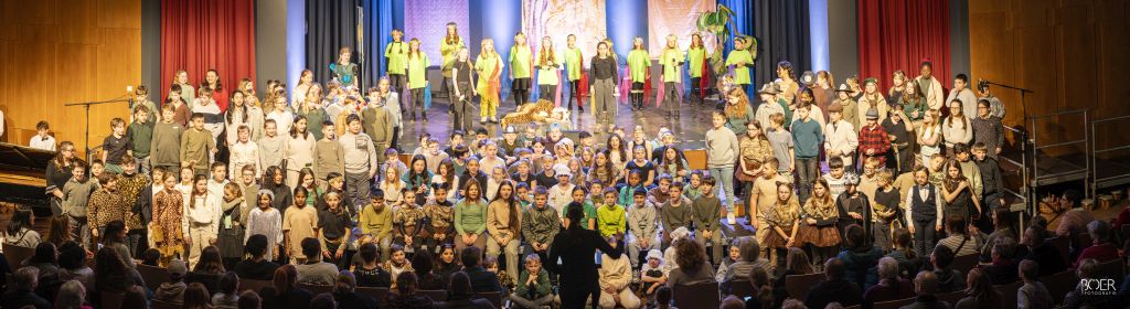 Gruppenbild des gesamten Ensamble des Unterstufenmusicals "Tikko Tiger und die Tiere der Madame"